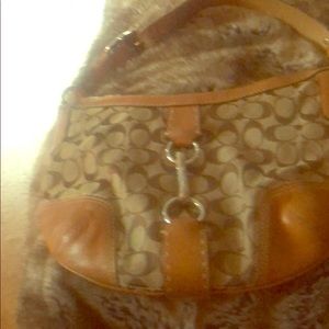 Light brown and tan coach handbag. clasp buckle